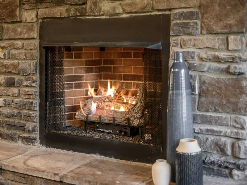 Warmth and ambiance abound by the crackling fireplace, perfect for cozy evenings indoors.