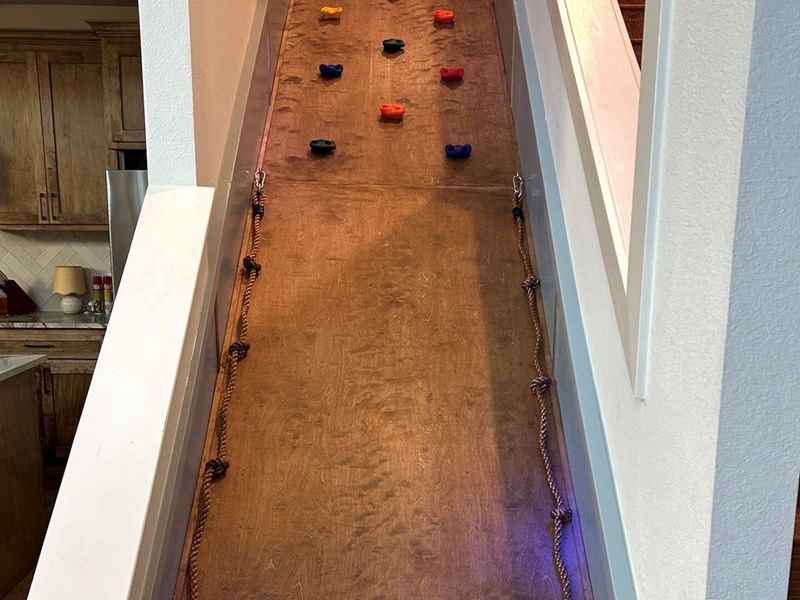 Unique indoor climb wall next to the staircase—an unforgettable feature kids love during their Broken Bow stay. 🌲🛝