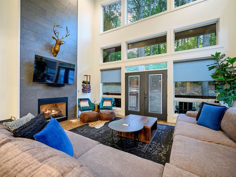 Bask in the glow of the fire while surrounded by soaring forest views — this open living room was made for laughter, relaxation, and unforgettable nights in.