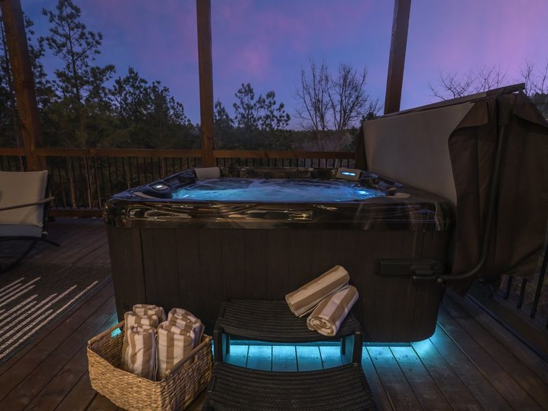 Relax in the bubbling hot tub while taking in breathtaking forest views.