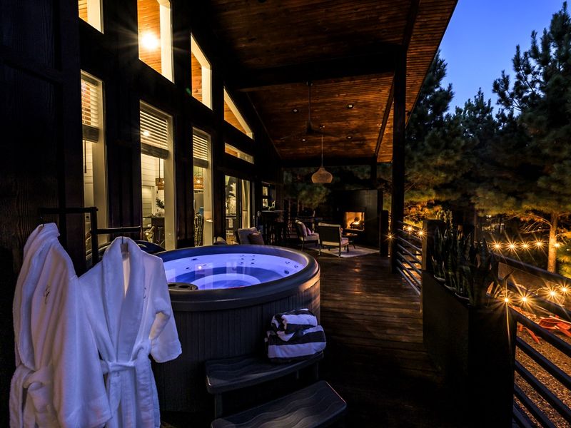 Evenings don’t get better than this — soak in the hot tub, sip wine, and watch the forest glow under string lights.