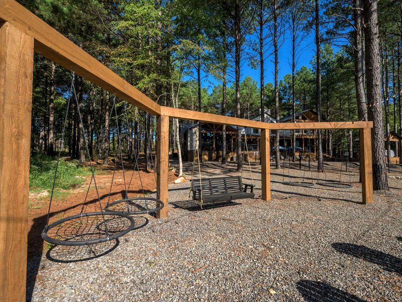 Oversized swings are nestled among the pines, creating a memorable outdoor experience at the luxury