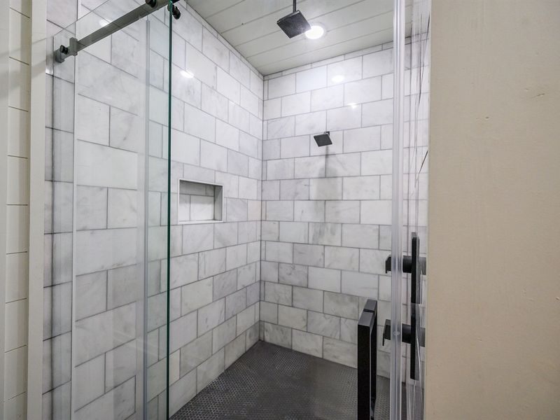 Step into a cloud of freshness with this pristine white tiled shower and let the water wash all your stress away.