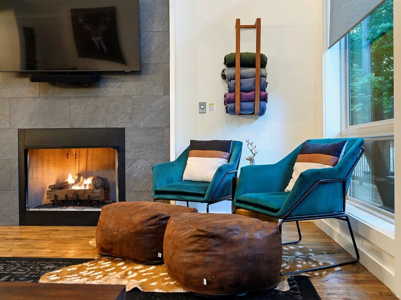 Sink into warmth and quiet — glowing fire, soft textures, and forest views that make this nook the perfect place to slow down