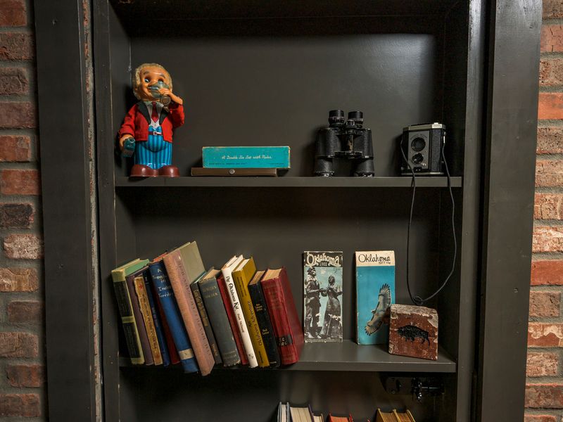 Explore the eclectic collection of vintage books, cameras, photographs, and memorabilia throughout the speakeasy.