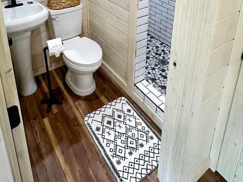 Bunk room's private bath with a trendy open shower design.