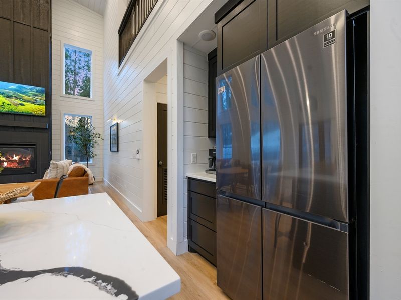 The full-size stainless steel refrigerator offers ample space for groceries and weekend getaway provisions, seamlessly blending into the kitchen’s modern design.