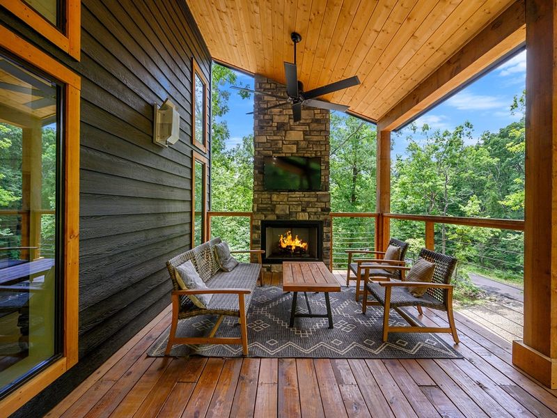 Imagine kicking back in style on this chic wooden deck, complete with a toasty fireplace and inviting furniture setup. Your relaxation sanctuary awaits!