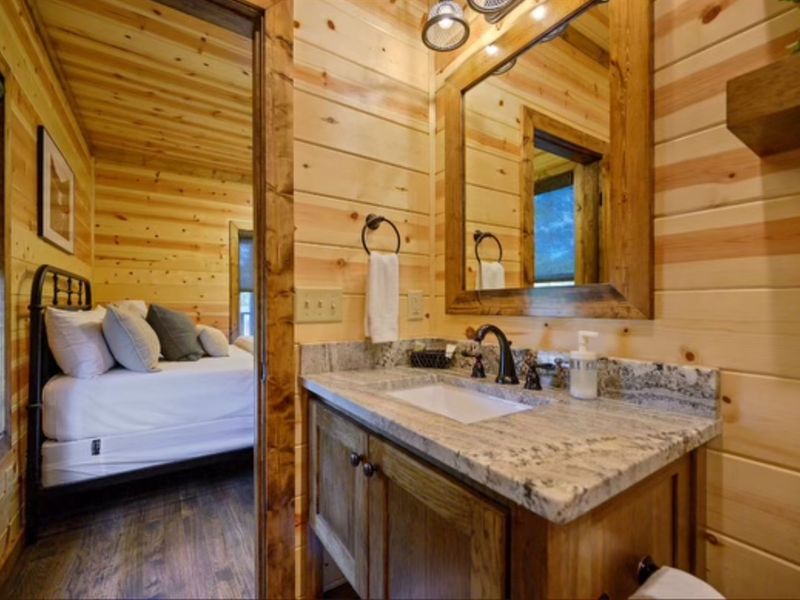 Cozy cabin interior showcasing a bathroom with a vanity and a glimpse of a bedroom