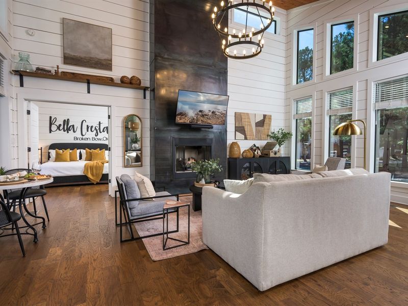 Relax where modern luxury meets the forest—an open living space with a statement fireplace and a peaceful bedroom nearby
