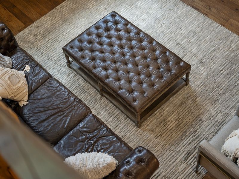 "Sink into the plush elegance of our Grant leather sofa, perfectly paired with a versatile ottoman, reflecting sophistication at every curve."