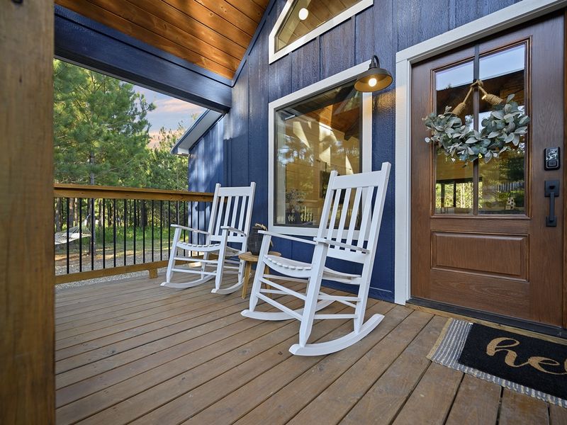 Adorable front porch invites you in with adorable rocking chairs