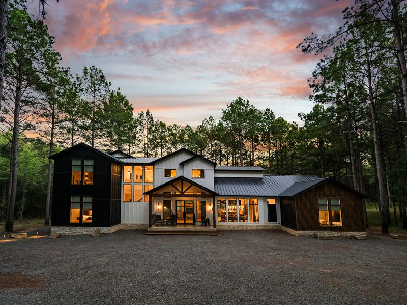 Luxury waterfront retreat, Bear Lake Lodge, nestled among pine trees at dusk, showcasing a stunning