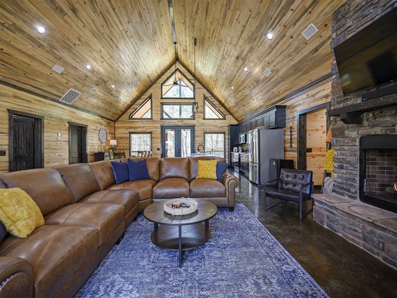 Embrace rustic elegance by the stone floor-to-ceiling fireplace, where warmth and charm meet in the heart of our living room.