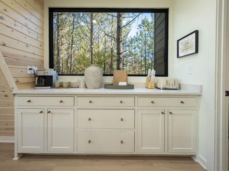 "Where the day's first coffee awaits in a cabin among the pines, readying us for adventure with every sunlit sip."