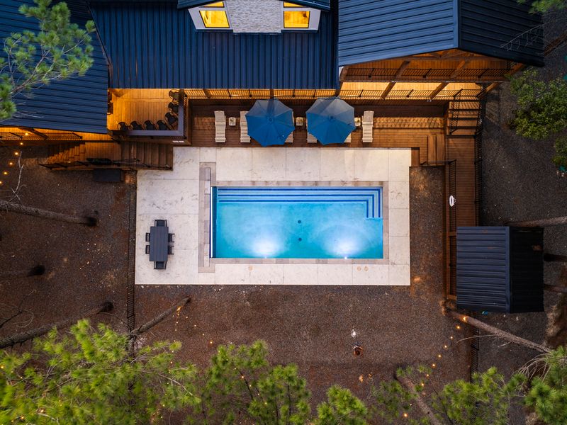 Aerial view of Bear Lake Lodge's luxurious pool terrace featuring a sparkling pool, outdoor dining