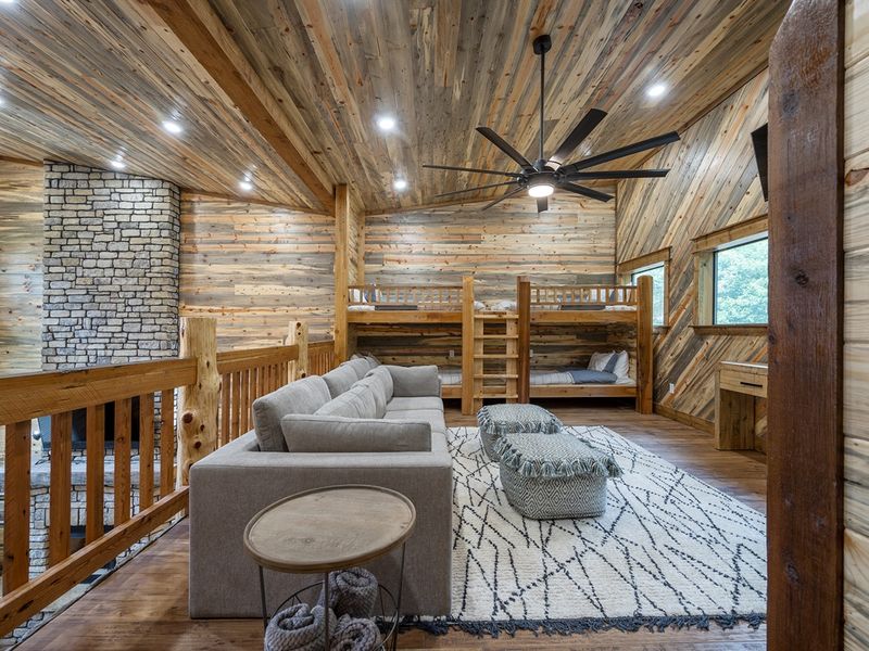 : "Kick back with family fun around the TV in our charming bunkroom lounge."