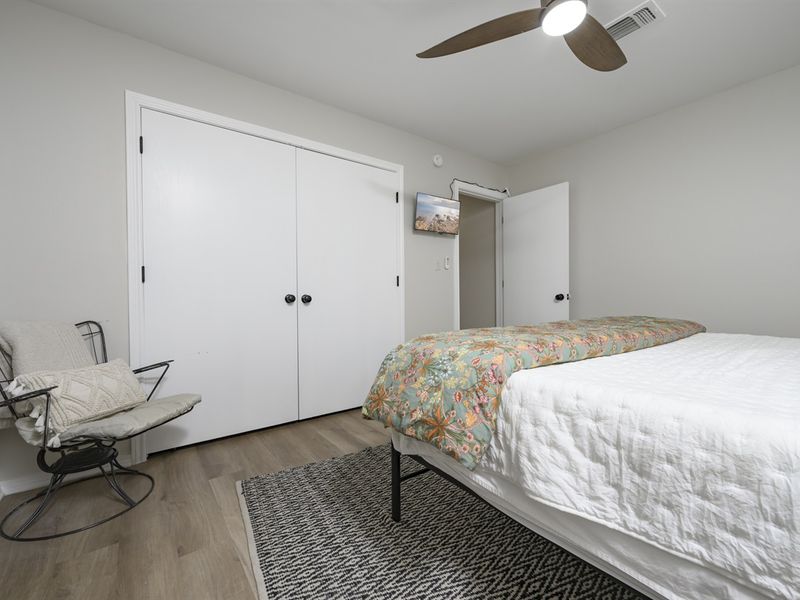 Cozy cabin interior showcasing a comfortable bed with floral bedding, a white wardrobe