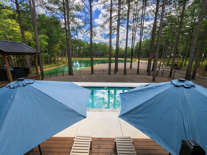 View from Bear Lake Lodge featuring a serene swimming pool with blue umbrellas, surrounded