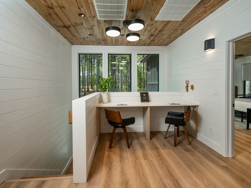 Tucked beside the bedroom, this sunny workspace offers a comfortable spot to catch up on emails or enjoy a quiet moment surrounded by the trees.