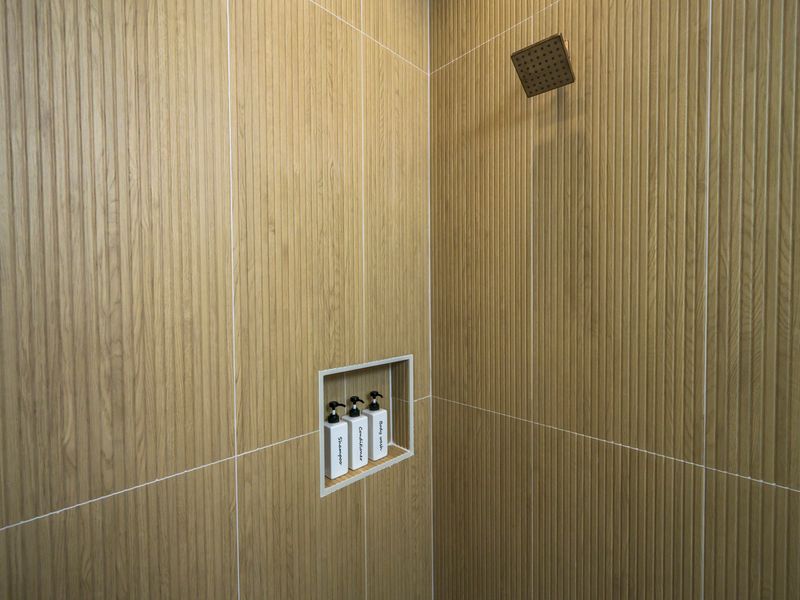 Refresh in the beautifully tiled walk-in shower, complete with a rainfall-style showerhead and convenient built-in toiletries.