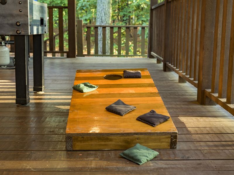 Wooden deck with cornhole game set up, suggesting comfortable and convenient outdoor recreation