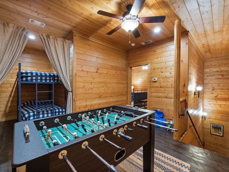 Head upstairs to the cabin's cozy bunk room, where hidden twin-over-twin bunks offer a private retreat for kids, and the foosball table promises hours of fun for all ages.