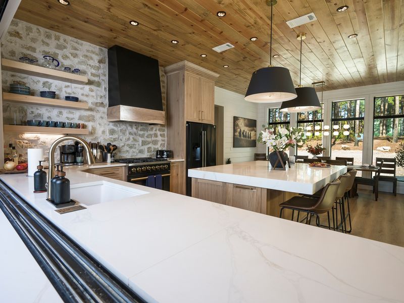 Modern farmhouse-style kitchen featuring a spacious island, premium appliances, and expansive windows offering views