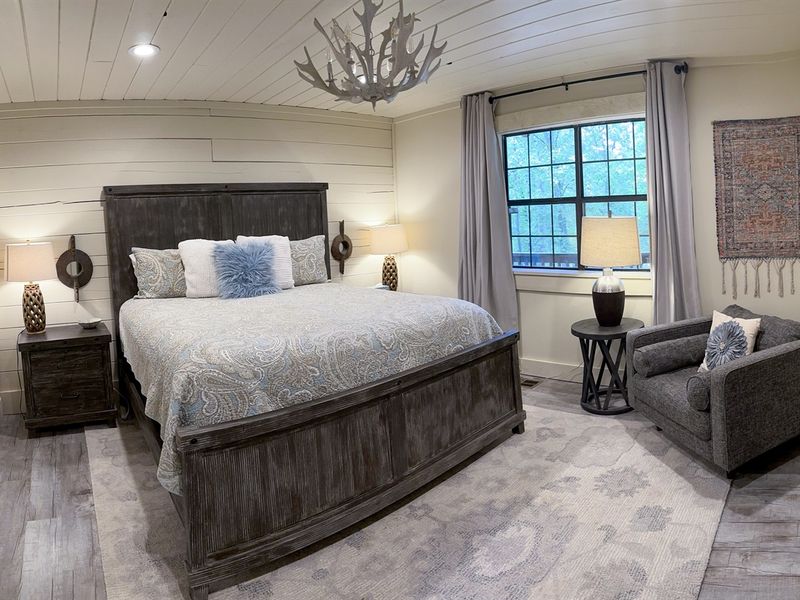 Dreamy nights await in our soothing sanctuary, where a majestic king bed invites you to unwind under the gentle glow of a captivating chandelier.