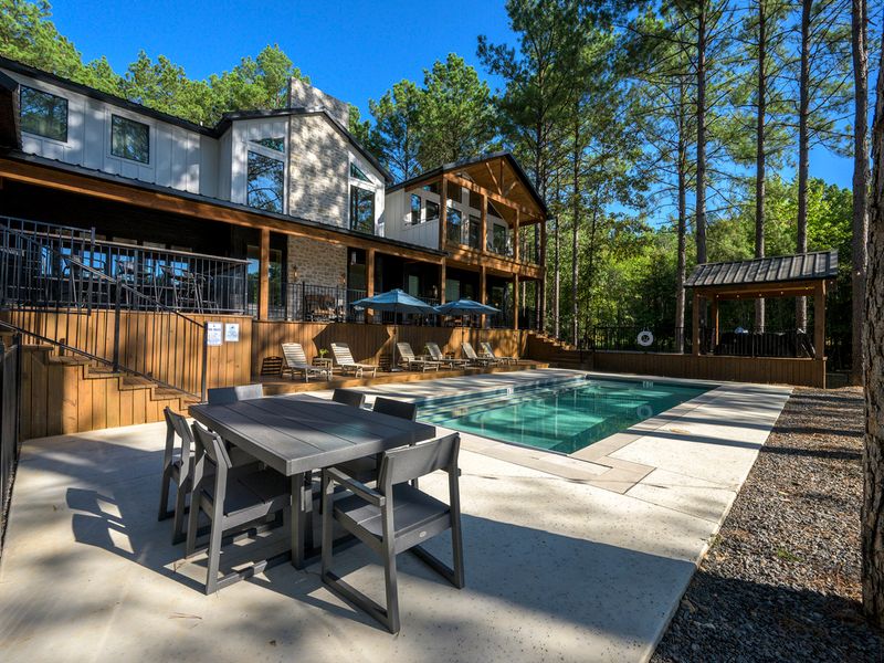 Spacious outdoor living area at Bear Lake Lodge featuring a modern pool, dining table
