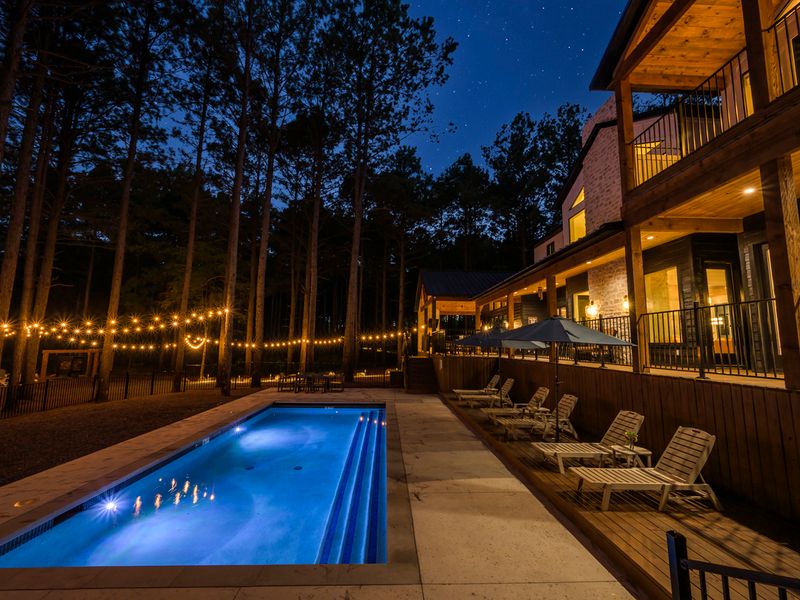 Illuminated pool and lounge area at Bear Lake Lodge, a luxury vacation rental, surrounded