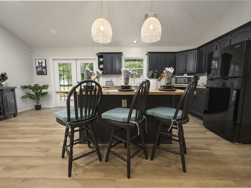 Modern kitchen interior showcasing a comfortable and convenient space for guests, featuring dark cabinetry