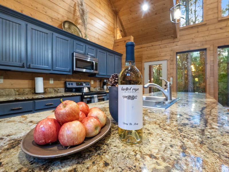The combination of striking blue cabinets, sleek granite counters, and top-of-the-line appliances brings a touch of luxury to your rustic getaway, making every meal prep a delight.