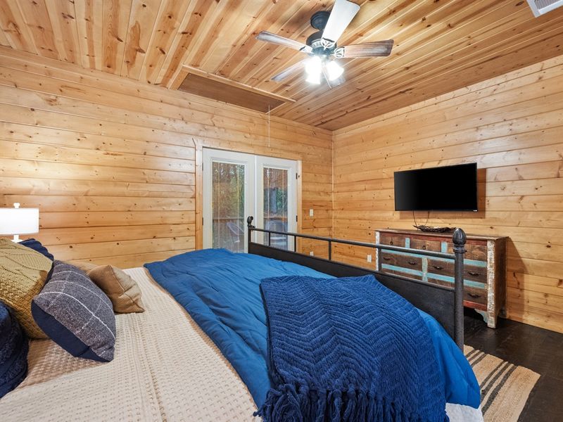 The spacious primary suite features cozy bedding, a Smart TV for your entertainment, and an ensuite for the perfect retreat after a day exploring Broken Bow-Hochatown.
