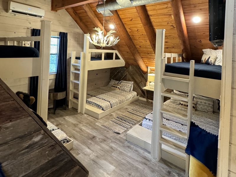 Adventure awaits in this charming bunk room featuring three twin over queen bunk beds - the perfect spot to rest after a day of fun! 🌲🛌