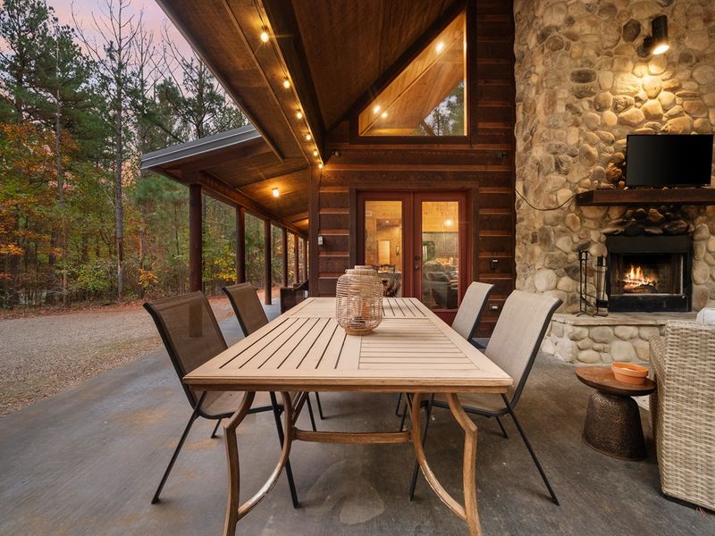 Enjoy the simple pleasures of dining outdoors, where every meal is made more special with the crackling warmth of the nearby fireplace and the beauty of your cabin retreat.
