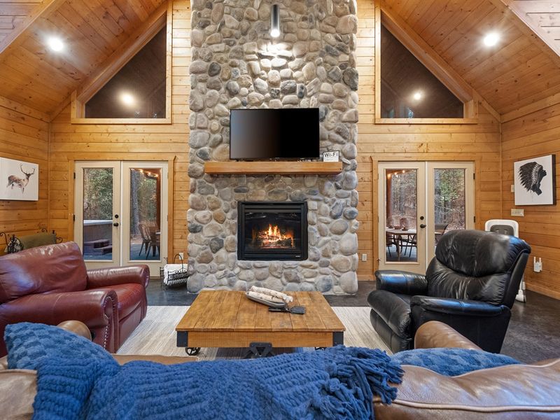 The stone fireplace takes center stage in this charming living room, providing warmth and ambiance for those cozy family nights by the fire in the heart of Broken Bow.