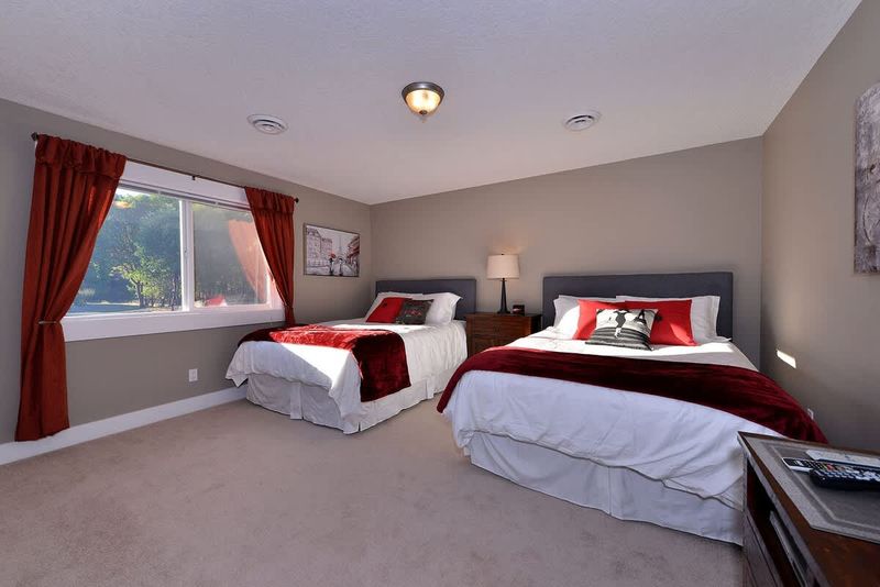 Third bedroom with two queen size beds. This bedroom also shares a four piece ensuite with the fourth bedroom. 