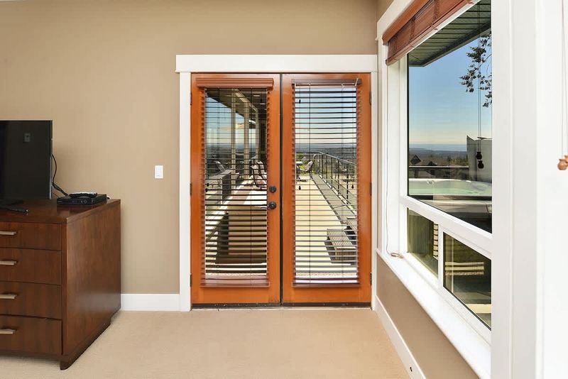 Upper Main level master bedroom with King bed and deck entrance.