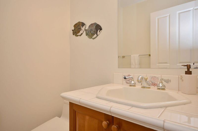 The half bath is located in the hallway next to the laundry room. 