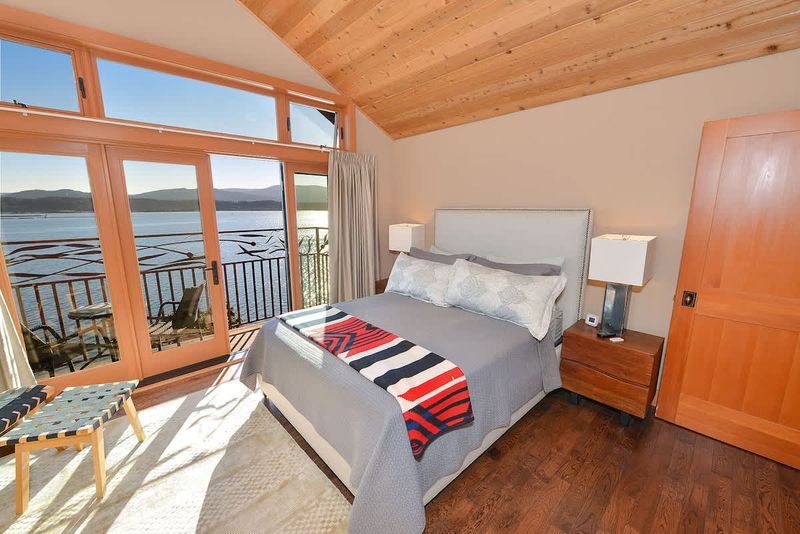 Primary bedroom with private balcony and sweeping bay views.