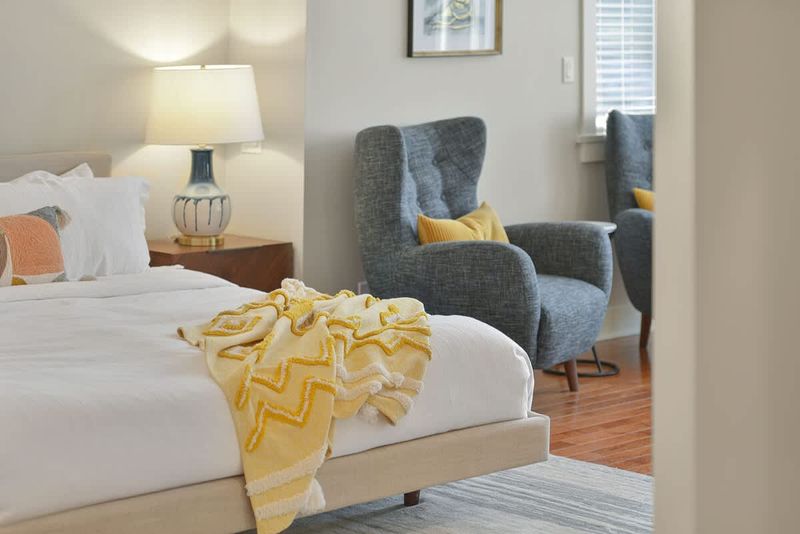 Primary bedroom king bed with private deck access and electric fireplace.