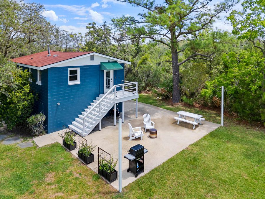 Exterior of the rental with a private back patio with plenty of seating and a grill!