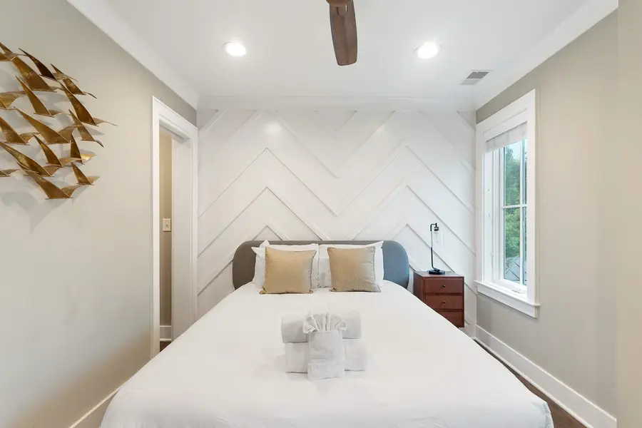 Bedroom 2: Bright and inviting with a queen bed, TV, reading chair, and en-suite bath.