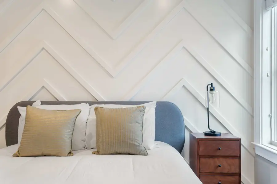Bedroom 2: Bright and inviting with a queen bed, TV, reading chair, and en-suite bath.