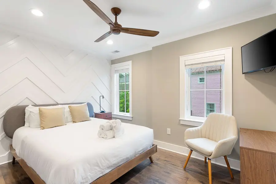 Bedroom 2: Bright and inviting with a queen bed, TV, reading chair, and en-suite bath.