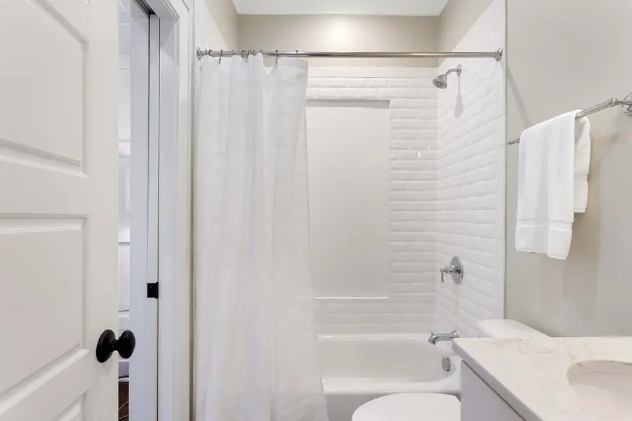 Bathroom 2: Spa-inspired bathroom featuring a walk-in shower and soaking tub.