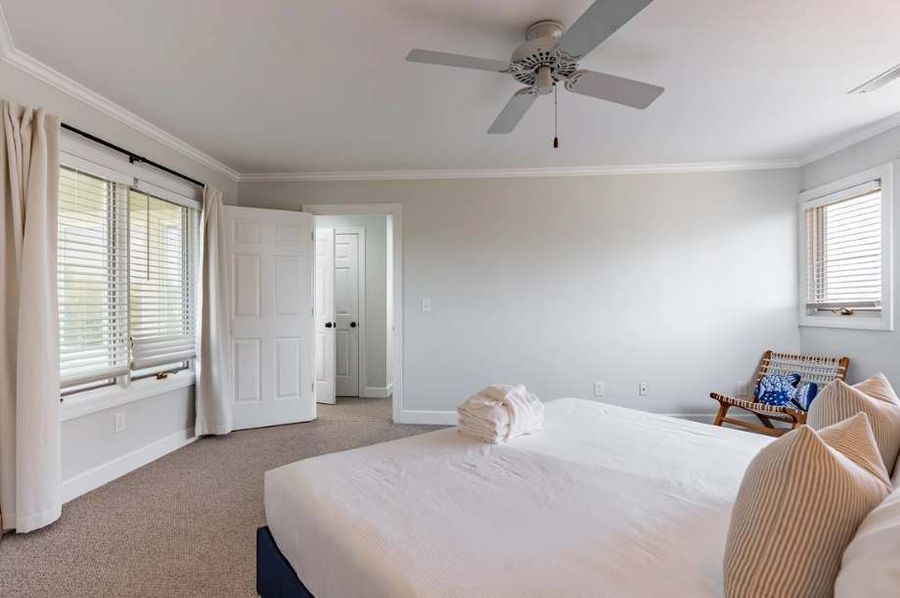 Retreat to a plush king-size bed in this spacious bedroom, where natural light floods the room and creates a warm, restful atmosphere.