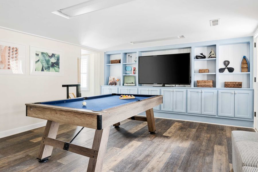 Downstairs gathering space with a pool table and TV 