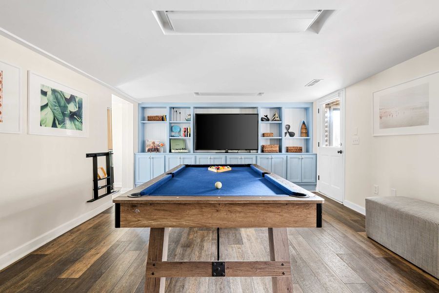 Downstairs gathering space with a pool table and TV 